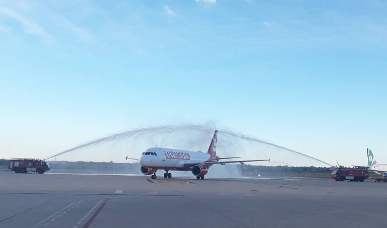El primer avión de Laudamotion, nueva compañía llegada en noviembre, cruza el tradicional arco de agua. Foto: AENA