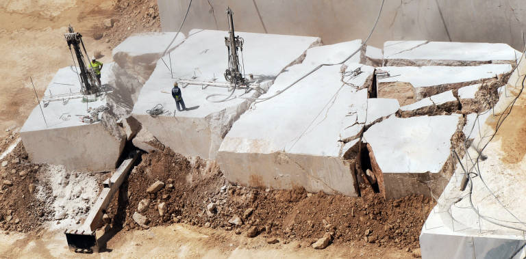 Empleados de Levantina sobre un gigantesco bloque de mármol en la cantera del Monte Coto. Foto: RAFA MOLINA