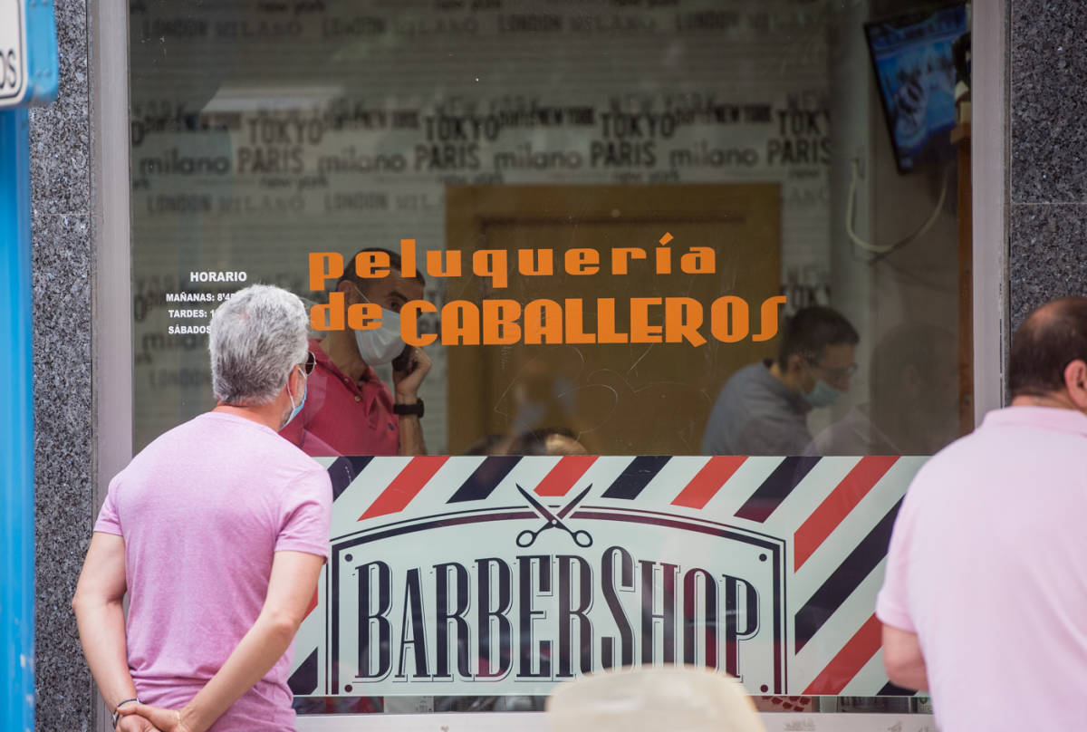 Clientes esperando fuera de la peluquería de caballeros Víctor Pérez