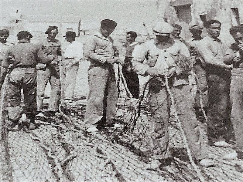 Foto de tabarquinos cosiendo las redes de pesca