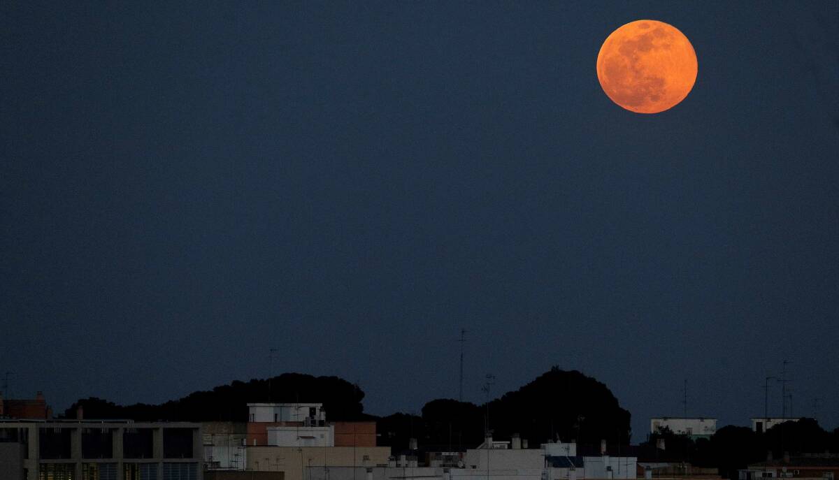 La Lluna sobre la ciutat de València. Foto: EFE/MANUEL BRUQUE