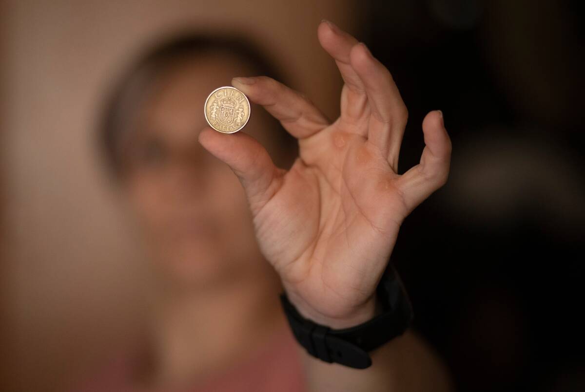 Una mujer sostiene una moneda de las antiguas pesetas. Foto: EDUARDO PARRA/EP