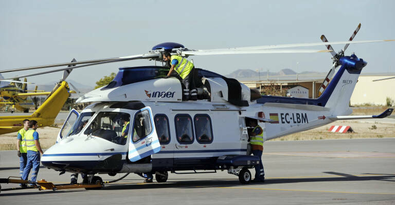 Técnicos trabajando en un helicóptero en el aeródromo de Mutxamel. Foto: RAFA MOLINA