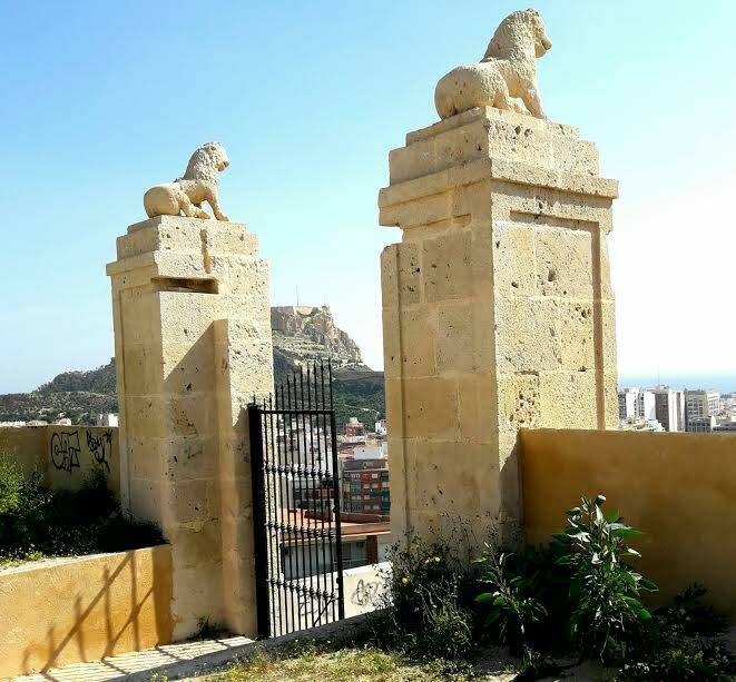 Vista de la puerta principal por detrás con las columnas con leones cada una